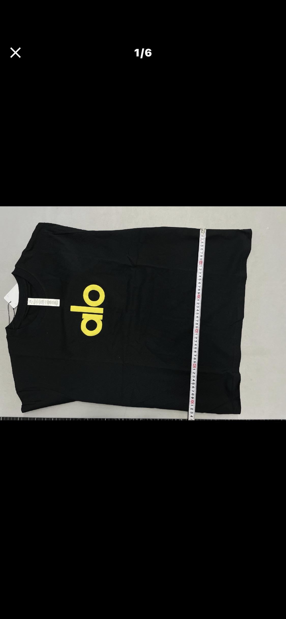 Black shirt photographed beside a measuring tape in the original sizing complaint